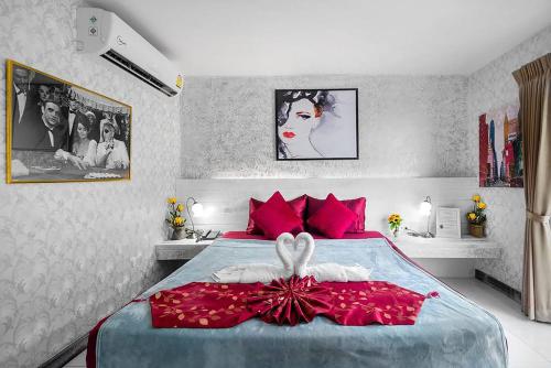 um quarto com uma cama com almofadas vermelhas em The Shades Hotel 50 meter Beach Front em Patong Beach