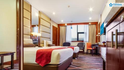 a hotel room with two beds and a desk at Cebu Parklane International Hotel in Cebu City