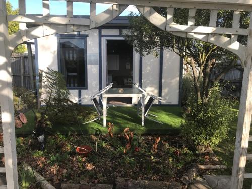 a lawn chair sitting in front of a garden at Sandy Feet Accommodation in Christchurch