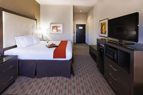 a hotel room with a large bed and a flat screen tv at Holiday Inn Express Frisco Legacy Park Area, an IHG Hotel in Frisco