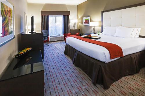 a hotel room with a large bed and a chair at Holiday Inn Express Frisco Legacy Park Area, an IHG Hotel in Frisco