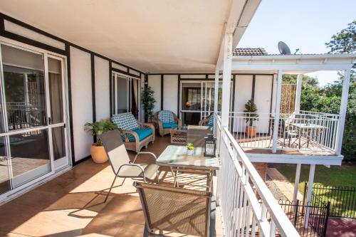 a patio with chairs and a table on a balcony at Ainslie Manor Guest House in Redcliffe