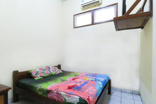 Cama en habitación con ventana en Hotel Erysa Juanda en Sedati