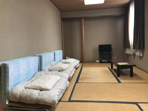 a living room with three couches and a table at Hibaso in Shōbara