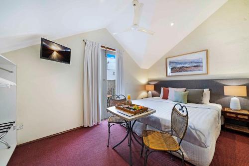 a bedroom with a bed and a table with chairs at Fremantle Port Mill Bed & Breakfast - Unique Accommodation in Fremantle