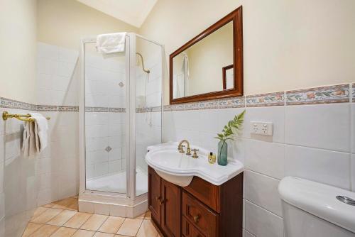 uma casa de banho branca com um lavatório e um chuveiro em Fremantle Port Mill Bed & Breakfast - Unique Accommodation em Fremantle