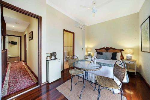 a bedroom with a bed and a table and chairs at Fremantle Port Mill Bed & Breakfast - Unique Accommodation in Fremantle