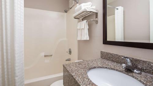 bagno con lavandino, servizi igienici e specchio di SureStay Hotel by Best Western Florence a Florence