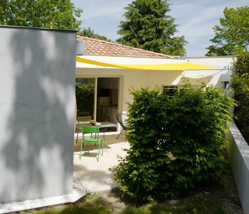 um pátio no quintal com uma mesa e cadeiras em La Maison des Hérissons em Bergerac