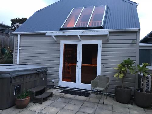 a house with a solar roof and a patio at Karori Cottage in Wellington