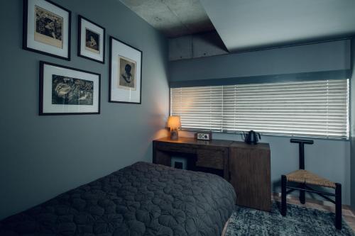 a bedroom with a bed and a desk and a window at node hotel in Kyoto