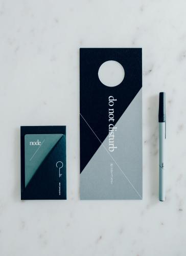 two brochures and a pen on a table at node hotel in Kyoto