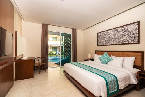 a hotel room with a bed and a television at Anja Jimbaran in Jimbaran