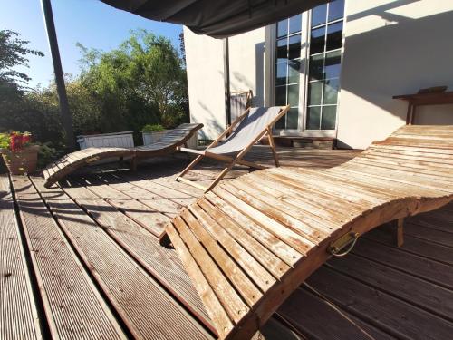 a wooden deck with a chair on a house at B&B Źródlana 46 in Olszyna