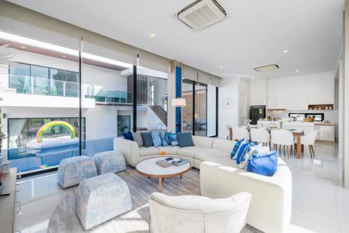 a living room with a couch and chairs and a table at Movenpick Residences 3-Bedroom Pool Villa Beach Access, Na Jomtien Pattaya in Na Jomtien