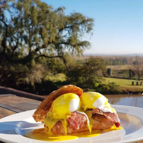 a sandwich with eggs on a plate on a table at Cheetau Lodge in Ebenhaezer