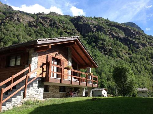 a house on a hill with mountains in the background at Il Maiolandro in Noasca