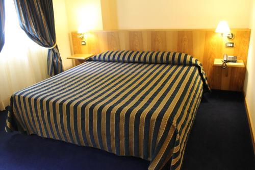 a hotel room with a bed with a striped blanket at La Fonte dell'Astore in Castelpetroso