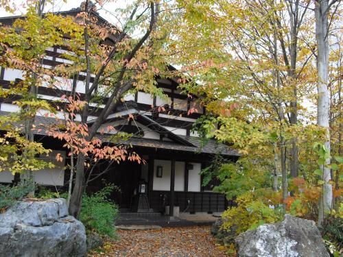 a black and white building with trees and rocks at Bunanoyado Koase in Aga