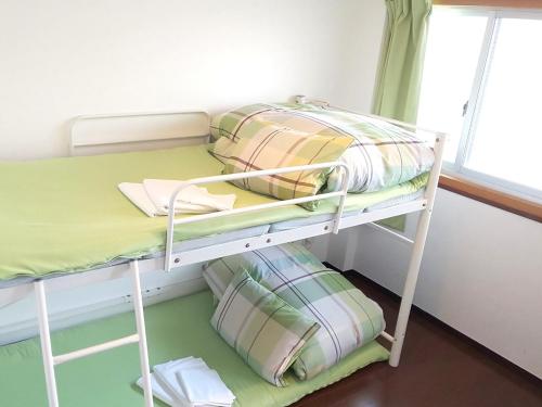 北九州的住宿－小倉福岡小亞洲旅舍，配有双层床的小客房内的双层床