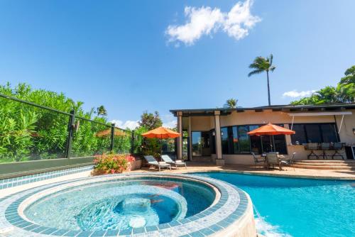 a swimming pool in front of a house at Noahs Hideaway Luxury B&B in Lahaina