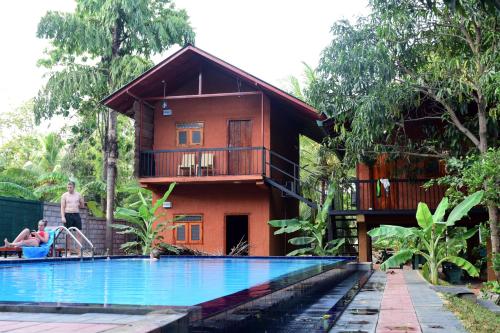 a house with a swimming pool in front of a house at Sun and Green Eco Lodge - Dambulla in Dambulla