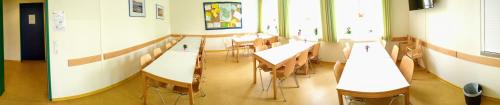 a room with tables and chairs in a classroom at Jugendherberge Friedrichstadt in Friedrichstadt