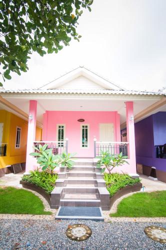 a pink house with stairs in front of it at Tum Baan Suan ตุ่มบ้านสวน in Chanthaburi