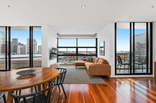 a living room with a table and a couch at Melbourne Holiday Apartments Flinders Wharf in Melbourne