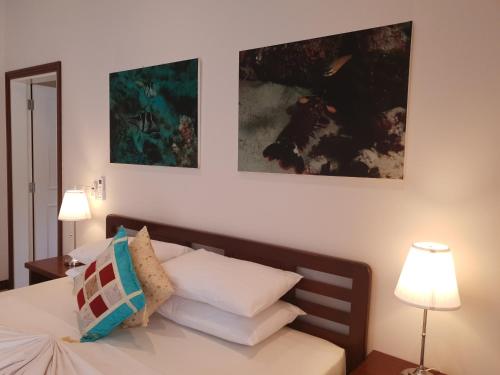 a bedroom with a bed with two pictures on the wall at Cote d'Or Footprints in Baie Sainte Anne