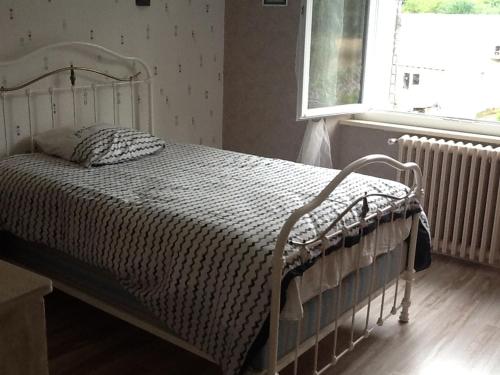 1 cama blanca en un dormitorio con ventana en Le rocher de bonnevie en Murat