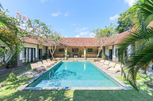a swimming pool in the backyard of a house at Bali Merita Villa in Canggu