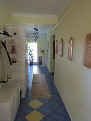 a hallway with a blue and yellow tile floor at Pásztor Fogadó in Martfů