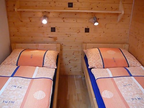 捷克布杰约维采Apartmány Hlava的一间木墙房间里有两张床