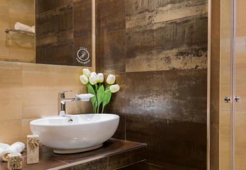 a bathroom with a sink and a vase of flowers at Forte 2 Hotel in Vieste