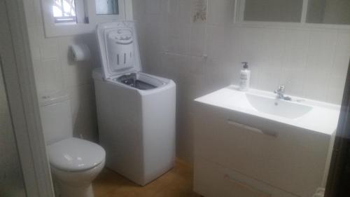 a white bathroom with a toilet and a sink at Morisca in Lloret de Mar
