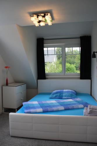 1 dormitorio con cama con sábanas azules y ventana en Ferienwohnung ANNA - charmante Ferienwohnung in bevorzugter Lage, en Constanza