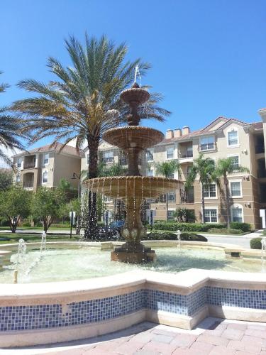 a fountain in front of a building with palm trees at Orlando Resort Rentals at Universal Boulevard in Orlando