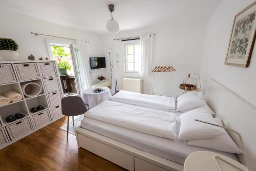 Un dormitorio blanco con una cama blanca y una ventana en B&B Haus Hemetzberger, en Hallstatt