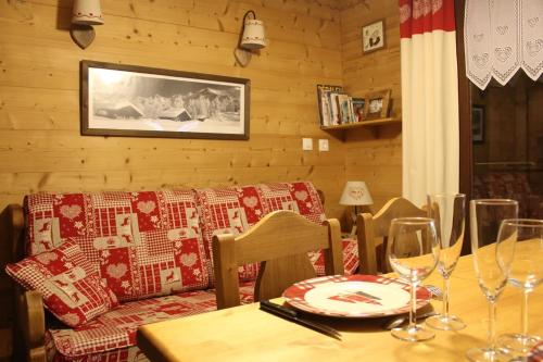 uma mesa com copos de vinho e um sofá num quarto em Chalet des pistes em Megève