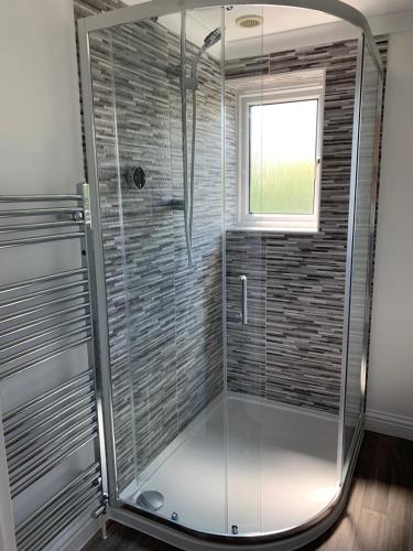 a glass shower in a bathroom with a window at Thorn House a beautiful large house in Witney in Witney