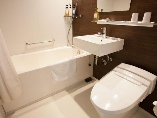 a bathroom with a white toilet and a sink at Henn na Hotel Tokyo Ginza in Tokyo