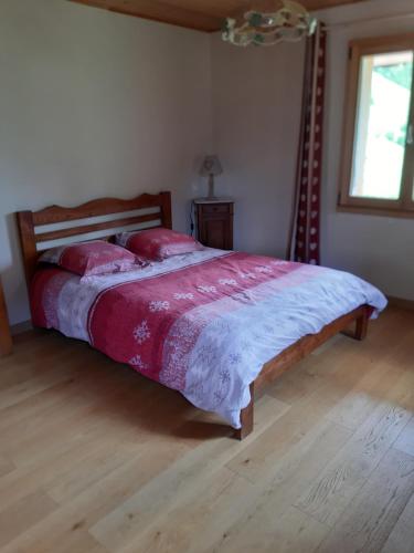 a bedroom with a large bed with red pillows at Le Chardon Bleu in Châtel