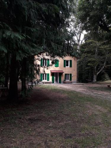 a house with green shutters on the side of it at CASA DELLE GUARDIE Rifugio in Madonna di Fornelli