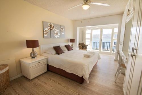 a bedroom with a large bed and a large window at Laguna Grove Holiday Rentals in Knysna