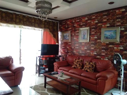 a living room with a red couch and a brick wall at Jem Jeff Residence Inn in Cabugao Norte
