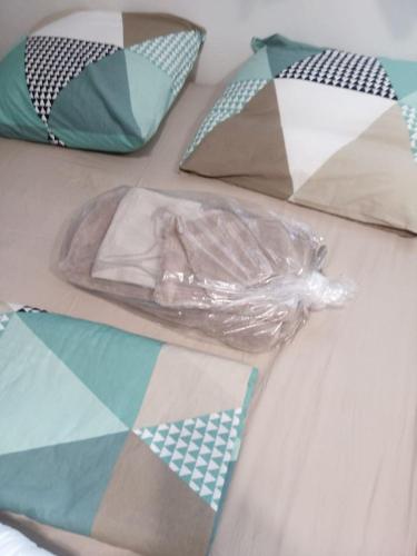 - un lit avec des oreillers et un sac en plastique dans l'établissement Charmant studio climatisé à 300m du port. Refait à neuf., à Bastia