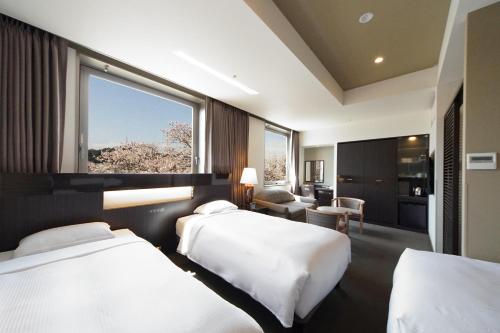 a hotel room with two beds and a window at Hotel Riverge Akebono in Fukui