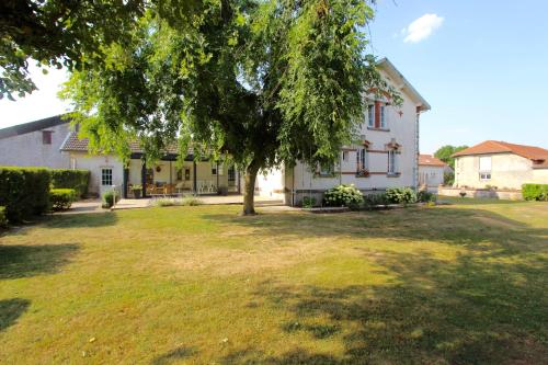 une maison blanche avec un arbre dans la cour dans l'établissement La maison de TOINETTE, à Jonchery-sur-Suippe