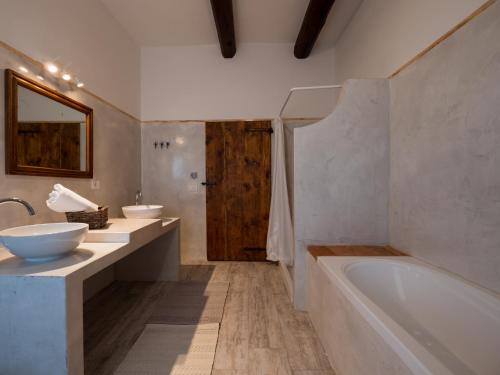 La Guest House della Tenuta di Tavignano في Cervidone: حمام مع مغسلتين وحوض استحمام